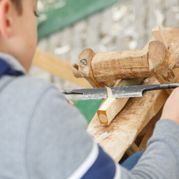 Spielmobil Bayreuth – Junge beim Holz bearbeiten