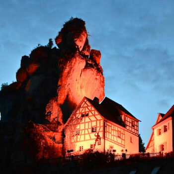 Felsen von Tüchersfeld bei Nacht, davor ist das alte Fachwerkhaus des Museums zu sehen