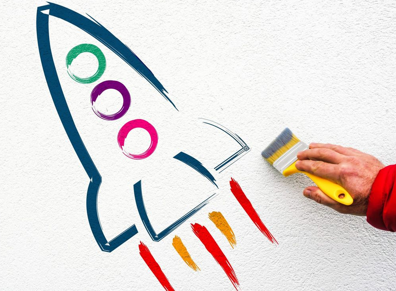 Ein Rakete wurde mit farbigem Pinsel auf eine weiße Wand gemalt.