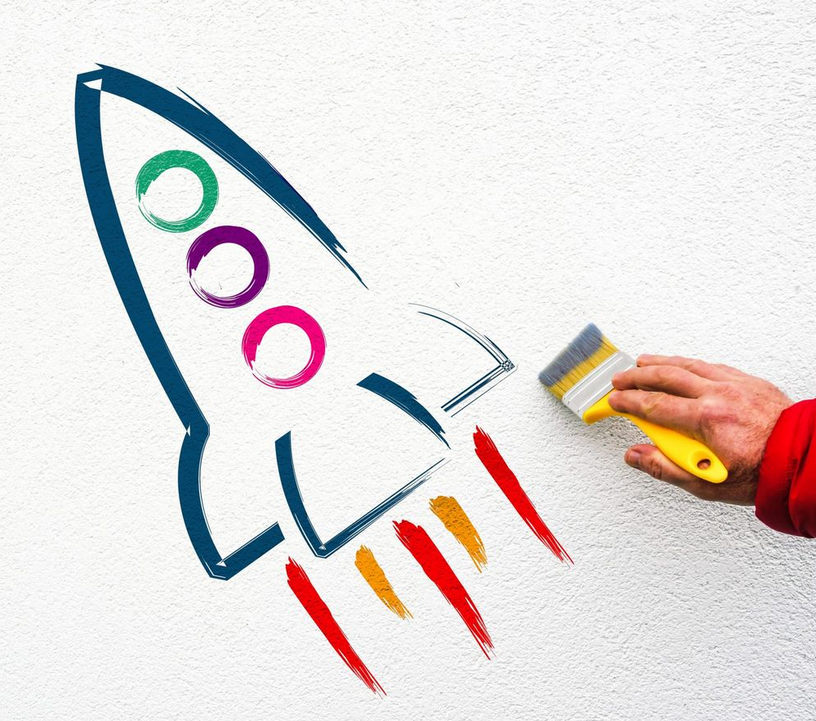Ein Rakete wurde mit farbigem Pinsel auf eine weiße Wand gemalt.