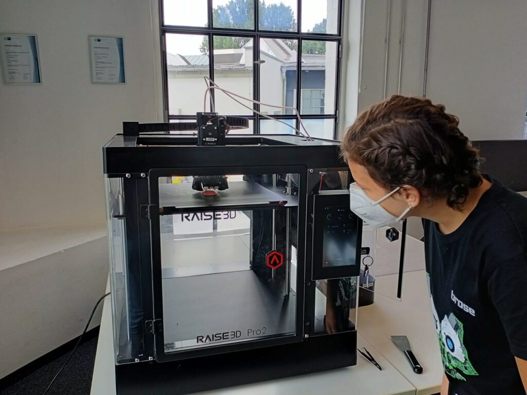 Eine Person betrachtet im 3D-Druck das Entstehen eines Druckmodells